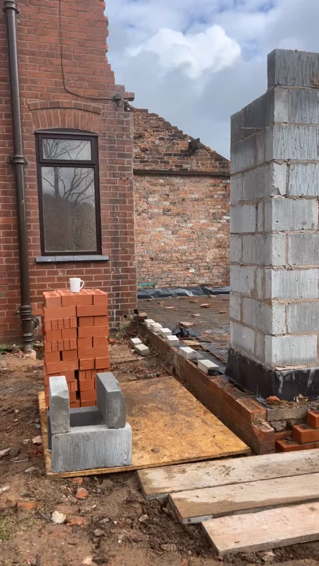 Concrete strip foundations with steel mesh and a new blockwork pier at the start of a groundworks job